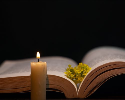 a burning candle and an opened bible